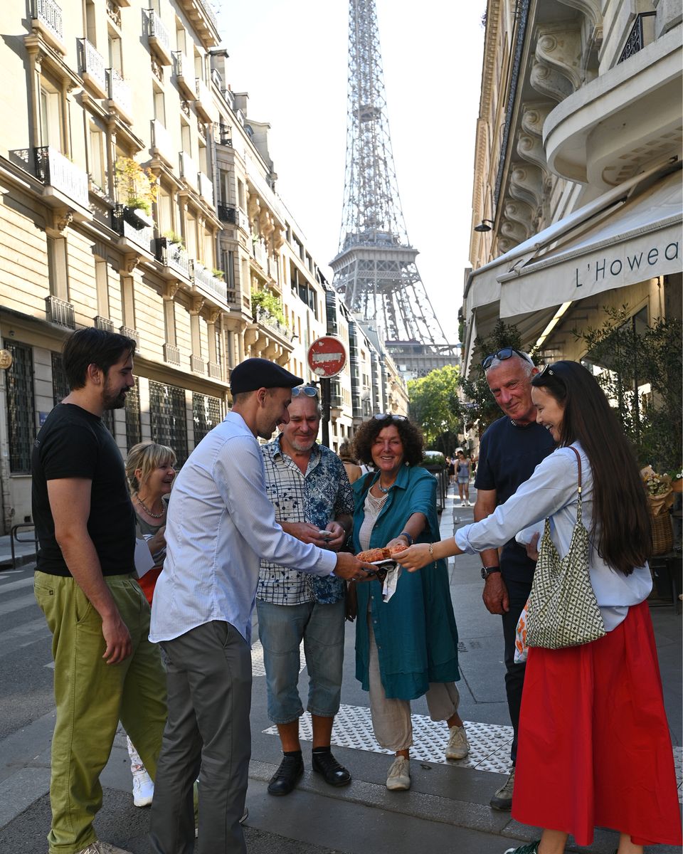 Our food tour group in a street of the 7th arrondissement, with the Eiffel Tower behind
